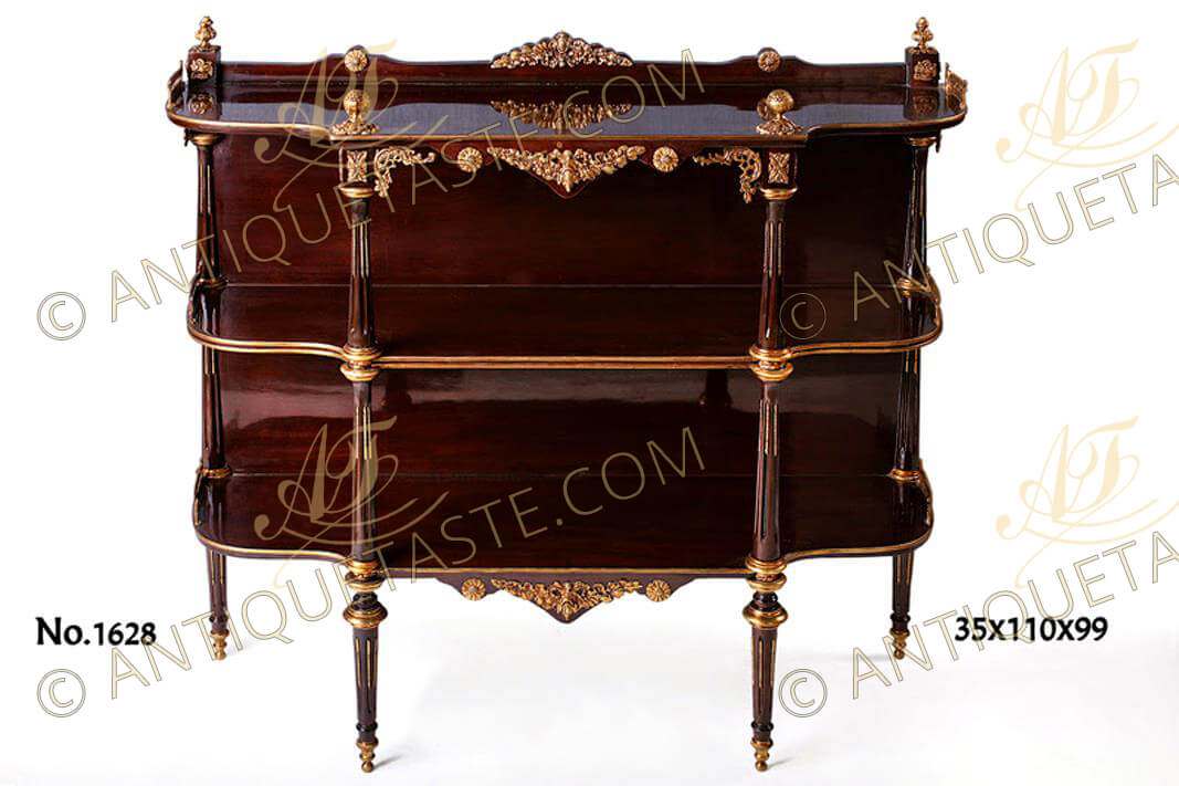 A magnificent and extremely elegant French 19th century Louis XVI style freestanding mahogany and ormolu D shaped dessert console, the highly finished scalloped breakfront top with an arbalete shaped backsplash crested by a sensational swaged foliate ormolu mount, two rosettes and two ormolu acorn on acanthus cap finials on each side above blocks with ormolu rosettes plus two pierced ormolu galleries on each side, The breakfront surmounted with exquisite ormolu walnut finials above a reversed arbalete shaped apron ornamented with a reverted swaged foliate ormolu mount as the above flanked by two rosettes and fine pierced two ormolu foliate C scrolls, the wooden backslash console has two tiers, each tier with two pierced ormolu galleries on each side, brass band on the contour, the central tier with double brass band and each has four supporting tapered shaped circular fluted columns with ormolu chandelles and caps, the lower tier is centered with a reversed arbalete shaped apron with foliate ormolu mount as the above, the console is raised on circular tapered fluted legs with ormolu chandelles, caps and terminating on tapering ormolu double circular ball sabots